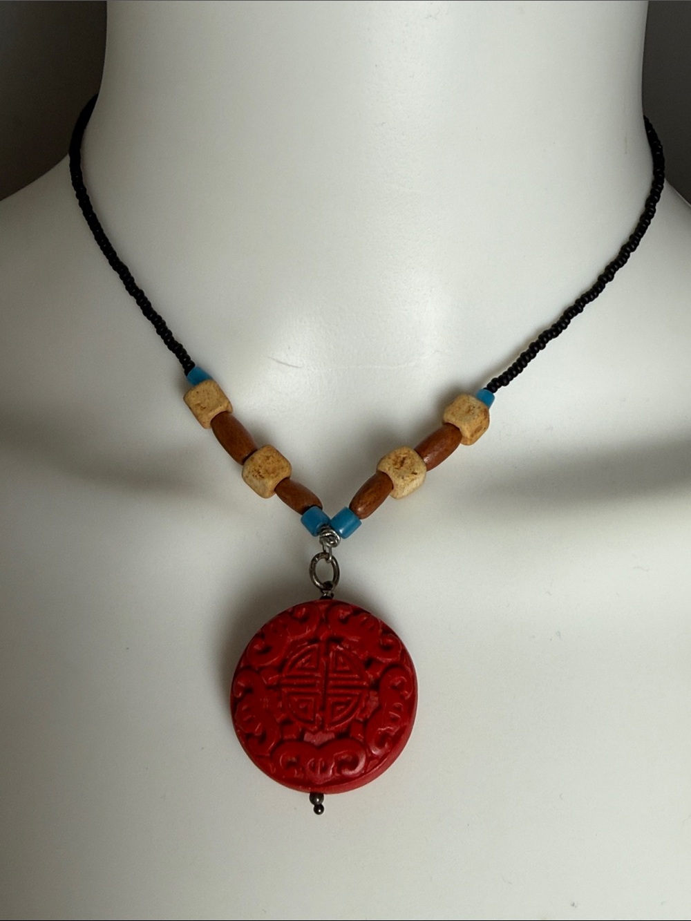 Beaded Black Necklace with Red Carved Cinabar Pendant and Turquoise Accents
